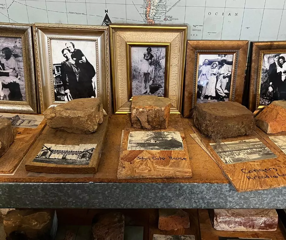 Framed black-and-white photos of Bonnie and Clyde with preserved bricks from historic buildings related to their story.