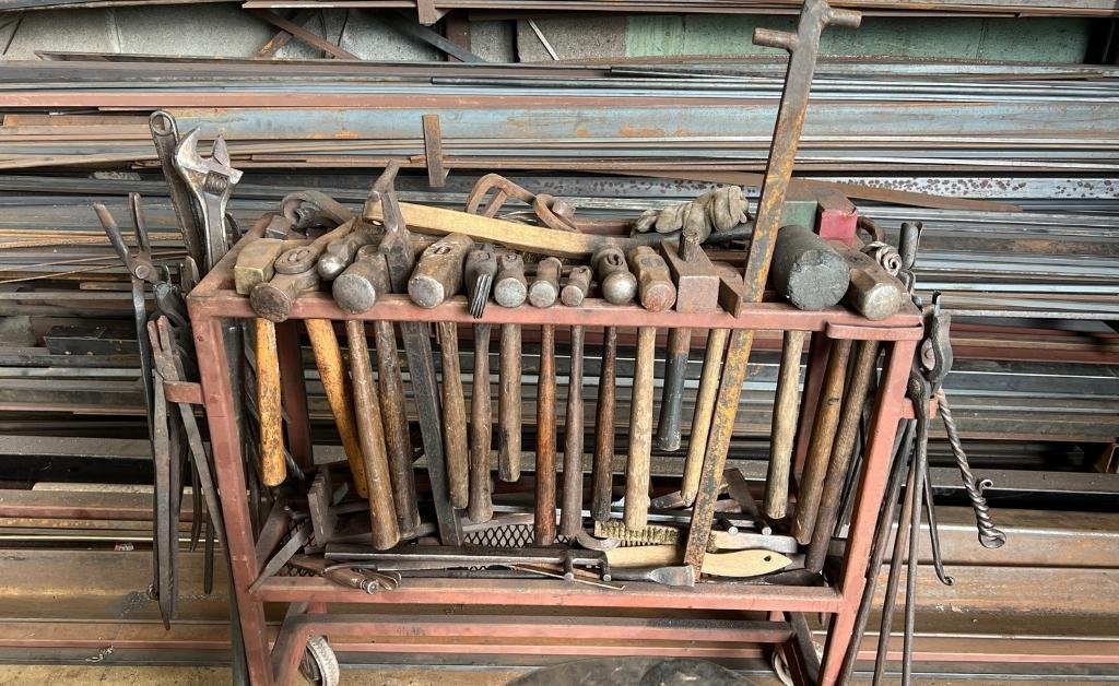 A rack filled with hammers, tongs, and hand tools used by master blacksmith Darryl Reeves in his New Orleans 7th Ward forge.
