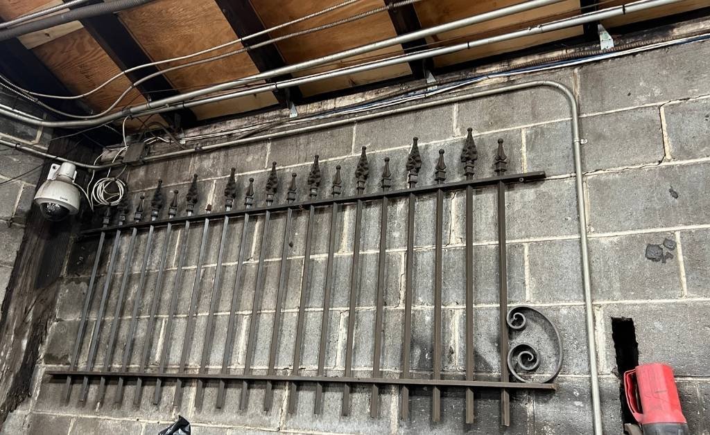 Antique wrought iron fence section with pointed finials, restored by Darryl Reeves and his team inside the 7th Ward workshop.
