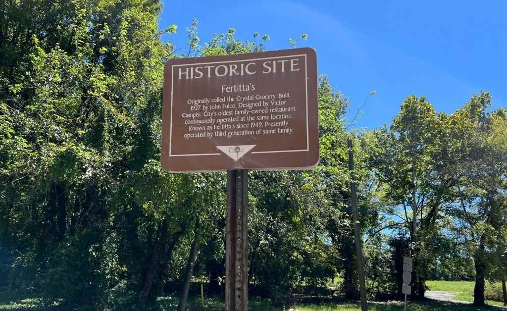 Historic site marker for Fertitta's in Shreveport, Louisiana, describing it as the city's oldest family-owned restaurant, built in 1927 and continuously operated by the Fertitta family.