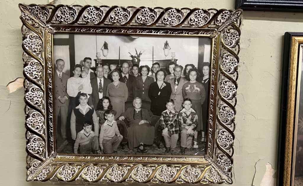 Framed black-and-white photo of the Fertitta family, showing multiple generations gathered together, displayed inside Fertitta's Deli in Shreveport.