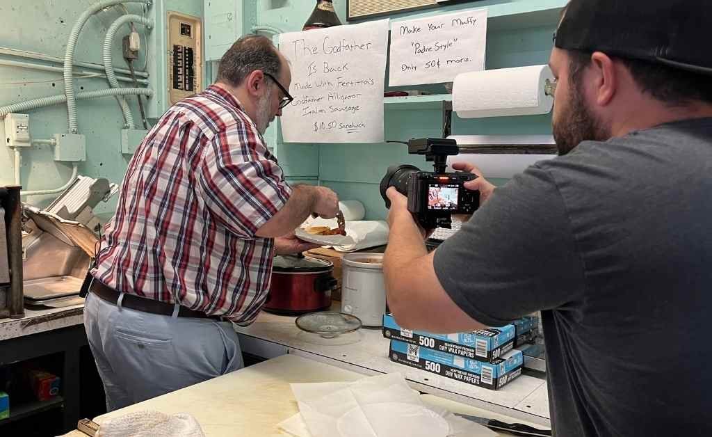Reverend Patrick Fertitta preparing the Godfather Sandwich with trademarked alligator Italian sausage while being filmed inside Fertitta's Deli kitchen.