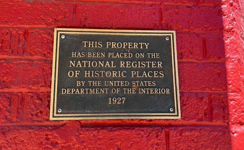 Bronze plaque mounted on a red brick wall stating that the property was placed on the National Register of Historic Places by the U.S. Department of the Interior in 1927.