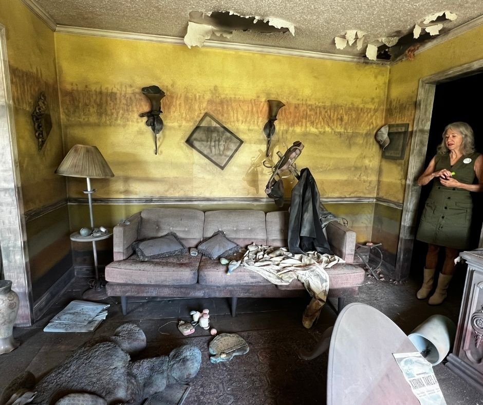 Water-stained walls, a damaged ceiling, and flood-damaged furniture preserved to show the aftermath of Hurricane Katrina.