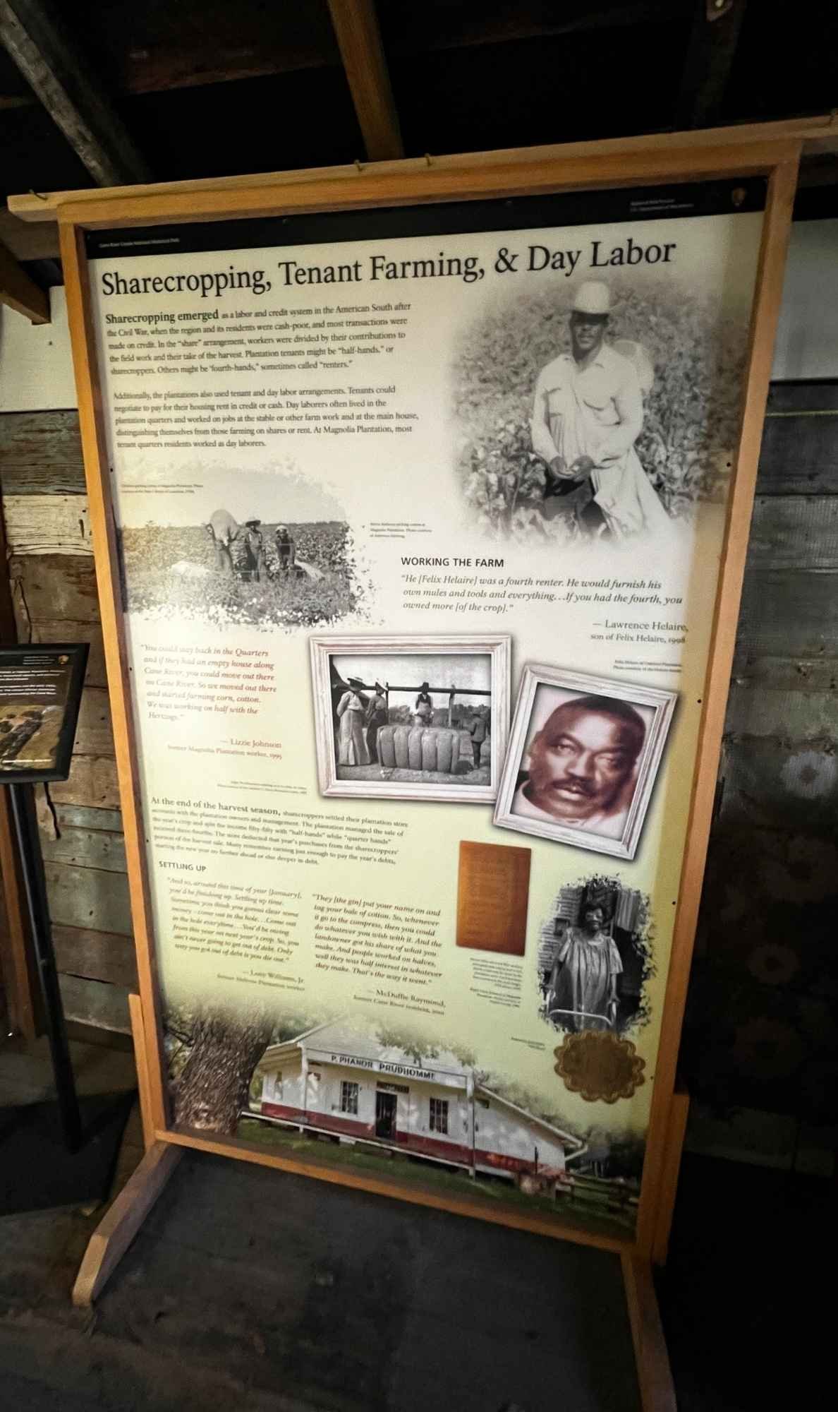Interpretive panel titled “Sharecropping, Tenant Farming, & Day Labor” at Oakland Plantation, displaying text, historic photos, and drawings that explain post-emancipation labor systems.