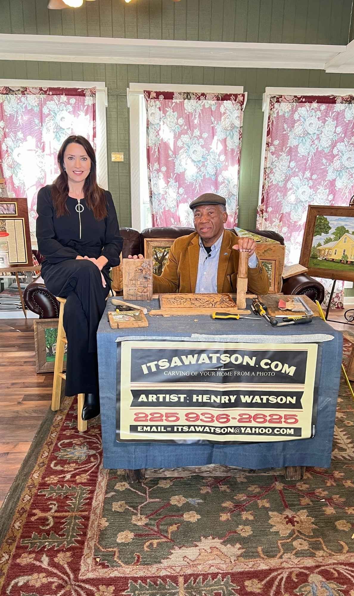Karen LeBlanc sits beside artist Henry Watson at his display table inside Butler Greenwood Plantation, surrounded by his cypress wood carvings.