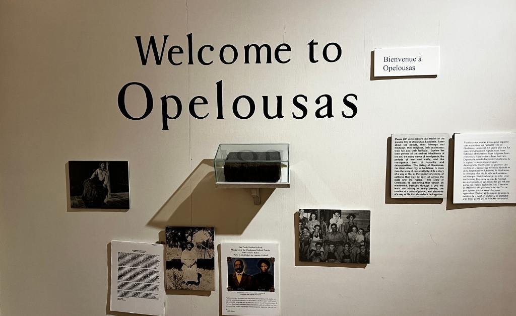 Wall display at the Opelousas Museum featuring the welcome text “Welcome to Opelousas” and historical photos and documents related to the city’s cultural heritage.