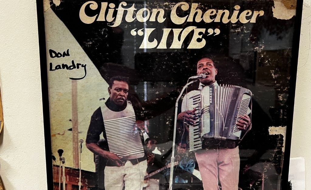 Close-up of a worn "Clifton Chenier LIVE" album cover showing Clifton Chenier singing and playing accordion with Don Landry beside him playing a rubboard.