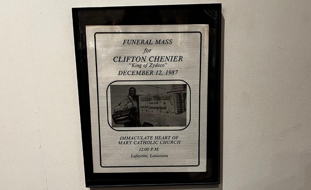 A framed funeral mass program for Clifton Chenier, titled “King of Zydeco,” dated December 12, 1987, held at Immaculate Heart of Mary Catholic Church in Lafayette, Louisiana.