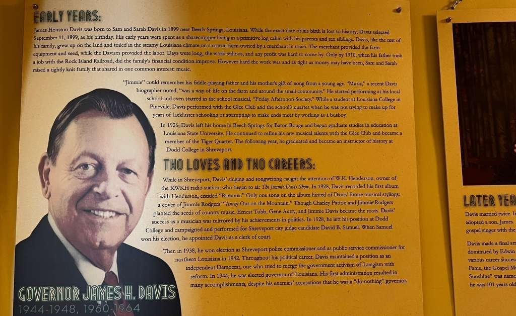 Informational display panel about Governor James H. Davis with a large portrait and biographical text detailing his early life, musical beginnings, teaching career, and eventual rise to the governorship of Louisiana.
