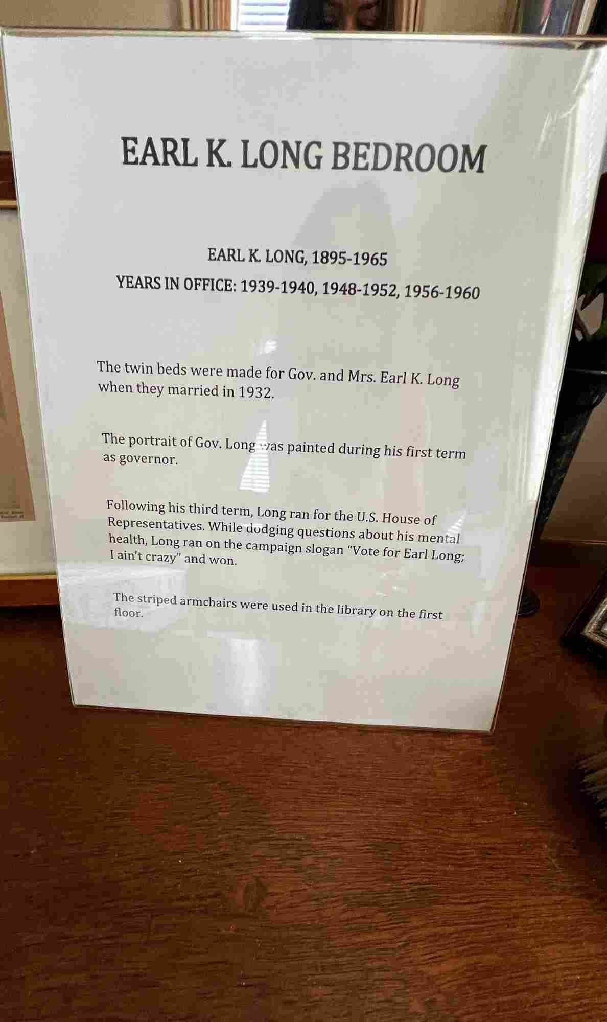 An informational placard inside the Old Governor’s Mansion detailing the history of the Earl K. Long Bedroom, including dates of his service, marriage details, and campaign slogan.