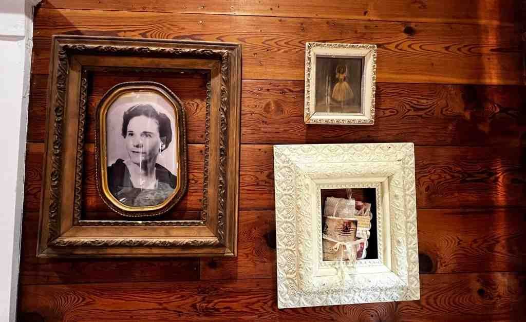Framed vintage family photographs displayed on a wood-paneled wall inside the Dover House in Florien, Louisiana