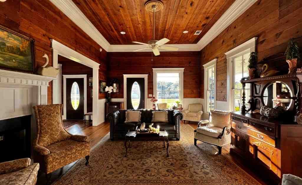 Living room inside the Dover House in Florien, Louisiana, featuring original wood walls, antique furnishings, and preserved historic details