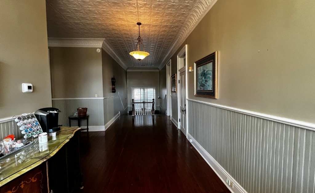 Guest coffee station along an interior hallway at The Caldwell House Bed and Breakfast in Abbeville, Louisiana, beneath pressed tin ceilings.