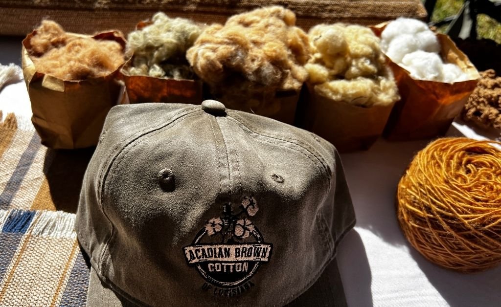 Acadiana brown cotton fibers and yarn displayed with a cap at Cajun Prairie Farm in Arnaudville, Louisiana.