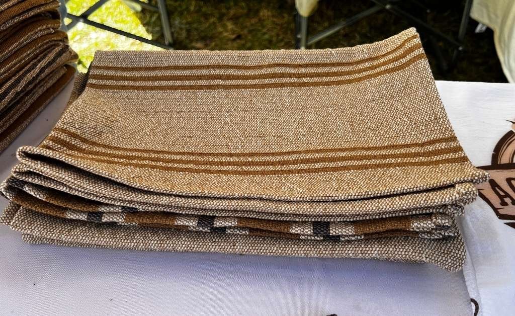 Folded handwoven brown cotton textiles displayed on a table at Cajun Prairie Farm in Arnaudville, Louisiana.