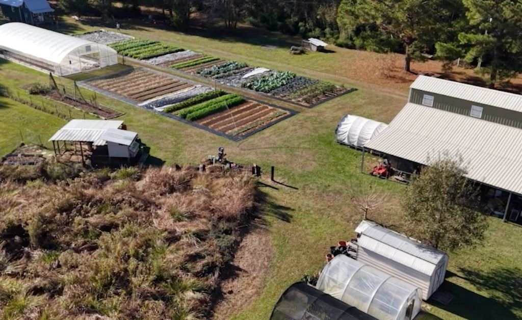 Aerial view of Cajun Prairie Farm showing vegetable plots, hoop houses, and farm buildings