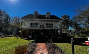 Front exterior of Maison Stephanie, a historic two-story home in Arnaudville, Louisiana, set along a brick walkway and garden.