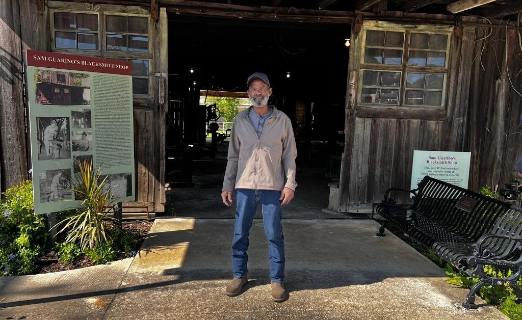 Brandon Briggs standing at the entrance of the Sam Guarino Blacksmith Shop Museum in downtown Abbeville, Louisiana.