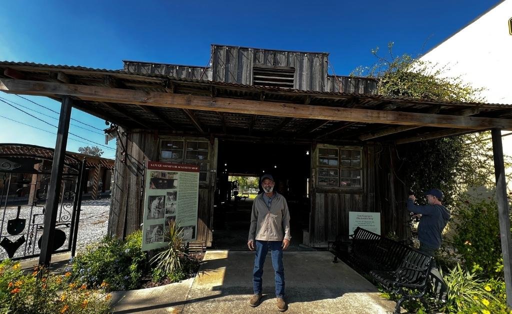 Brandon Briggs standing at the entrance of the Sam Guarino Blacksmith Shop Museum in downtown Abbeville, Louisiana.