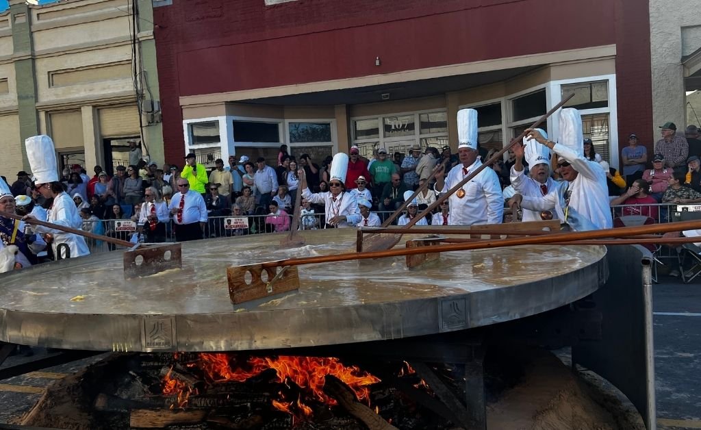 Chevaliers stir the giant omelette in a massive skillet during the Giant Omelette Celebration in downtown Abbeville, Louisiana