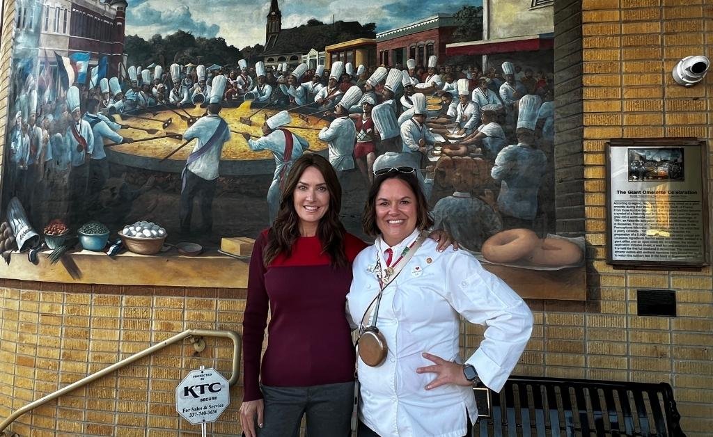 Karen LeBlanc poses with the Mayor of Abbeville in front of the Giant Omelette Celebration mural in downtown Abbeville.