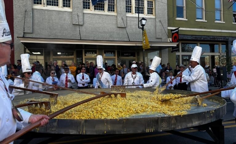 Chevaliers stirring a giant omelette made from thousands of eggs during the Giant Omelette Celebration in downtown Abbeville, Louisiana