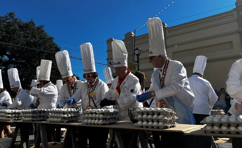 Chevaliers crack eggs by hand during the Giant Omelette Celebration in downtown Abbeville, Louisiana