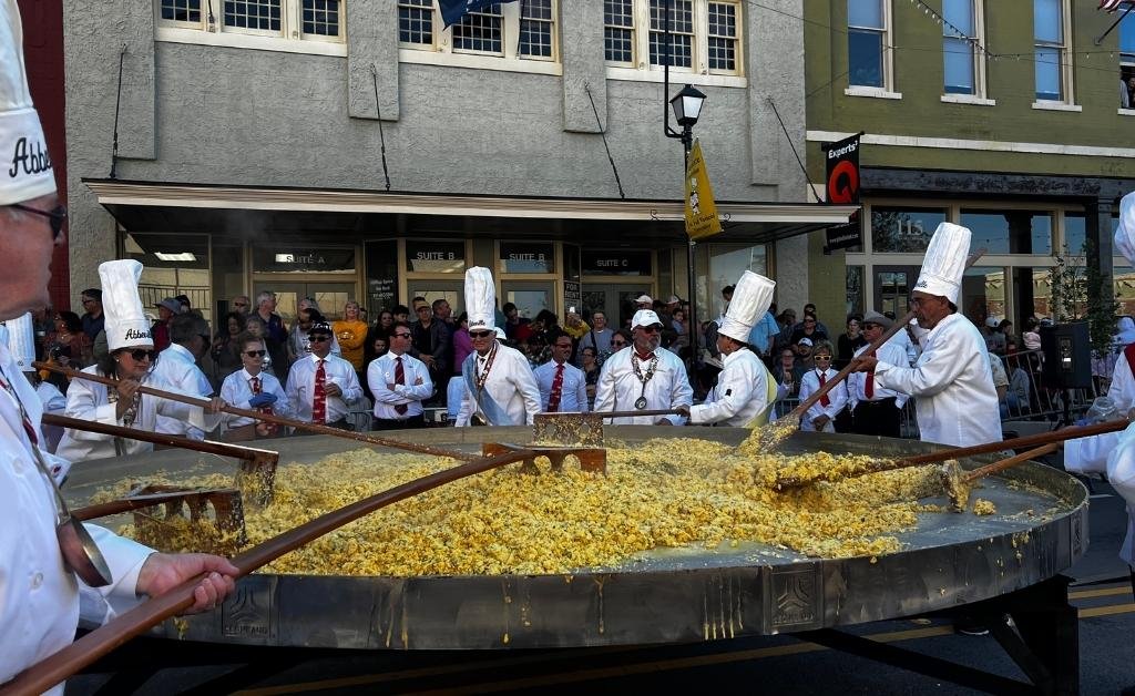 Chevaliers stirring a giant omelette made from thousands of eggs during the Giant Omelette Celebration in downtown Abbeville, Louisiana