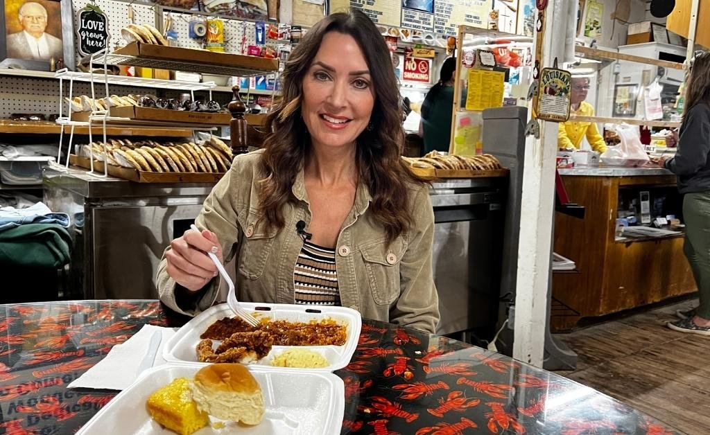 Karen LeBlanc seated inside Suire's Grocery and Restaurant with a plate of turtle sauce picante and sides