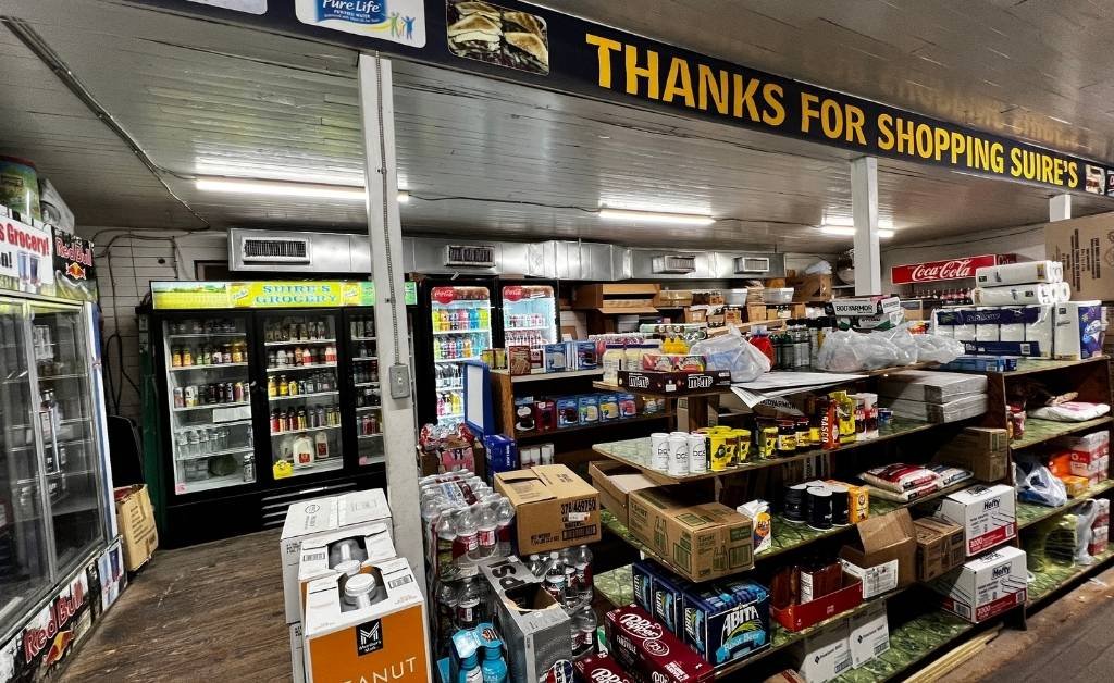 Interior of Suire's Grocery and Restaurant showing stocked shelves and beverage coolers